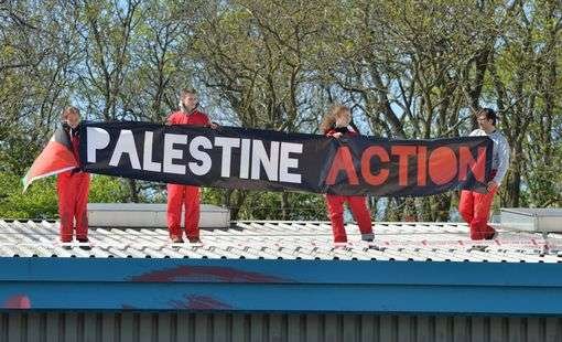Pro Palestinian protesters on the roof of the Israeli owned arms factory