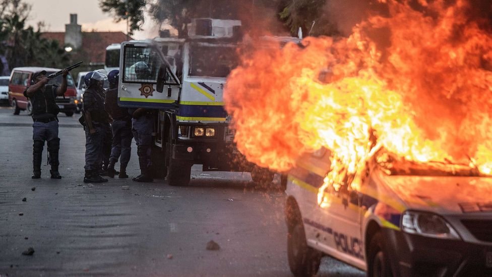 A South African police van is set on fire following protests